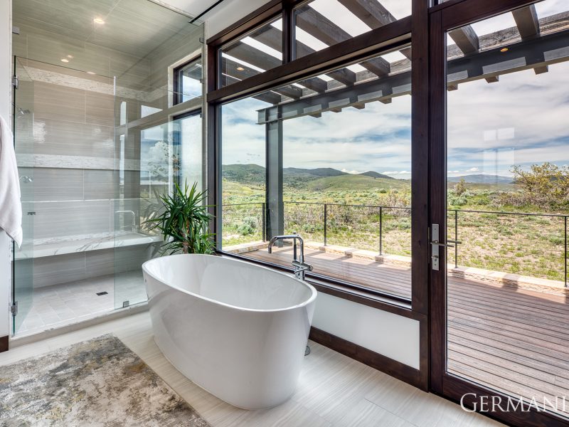 Featured here is a soaker bath tub and adjacent walk in shower with bench. Did we mention this bathroom also has a walk out deck?!