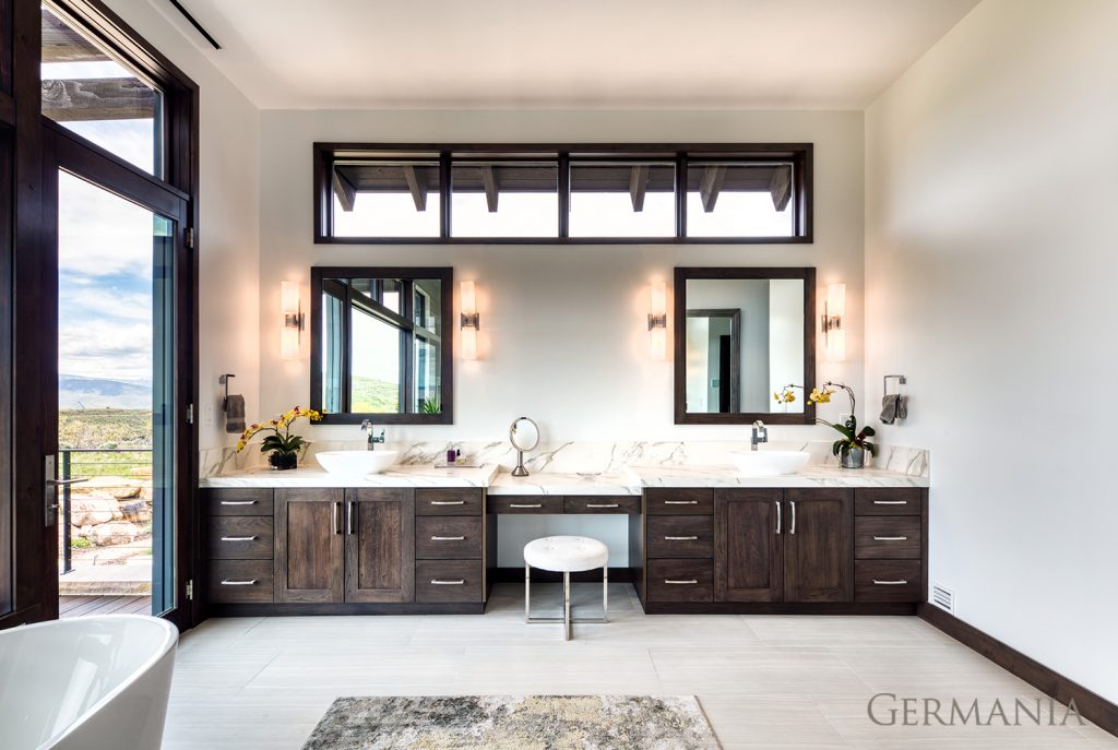 Dual sinks, stone slab countertops, custom sconces, and gorgeous views make creating a dream house master bedroom in your reach. This is just one of many examples of the craftmanship from Germania.