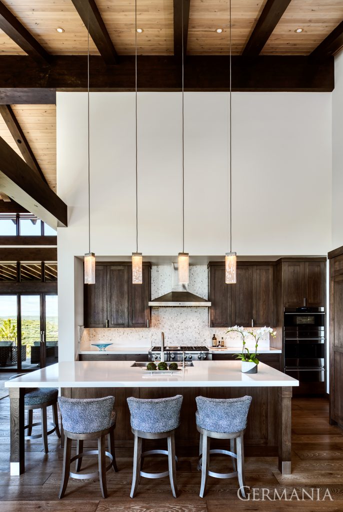 Featured here in this custom luxury home kitchen is custom light fixtures, tongue and groove ceilings, and custom cabinetry.