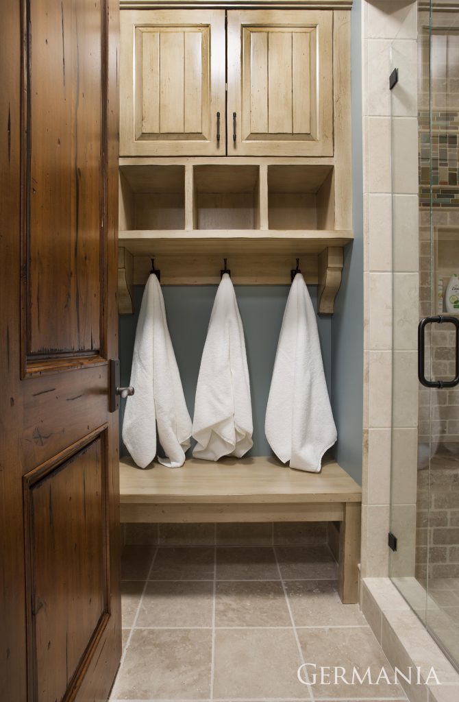 This walk in shower with ample closet space and an area to hang towels and clothes is a nice addition for this custom bathroom.