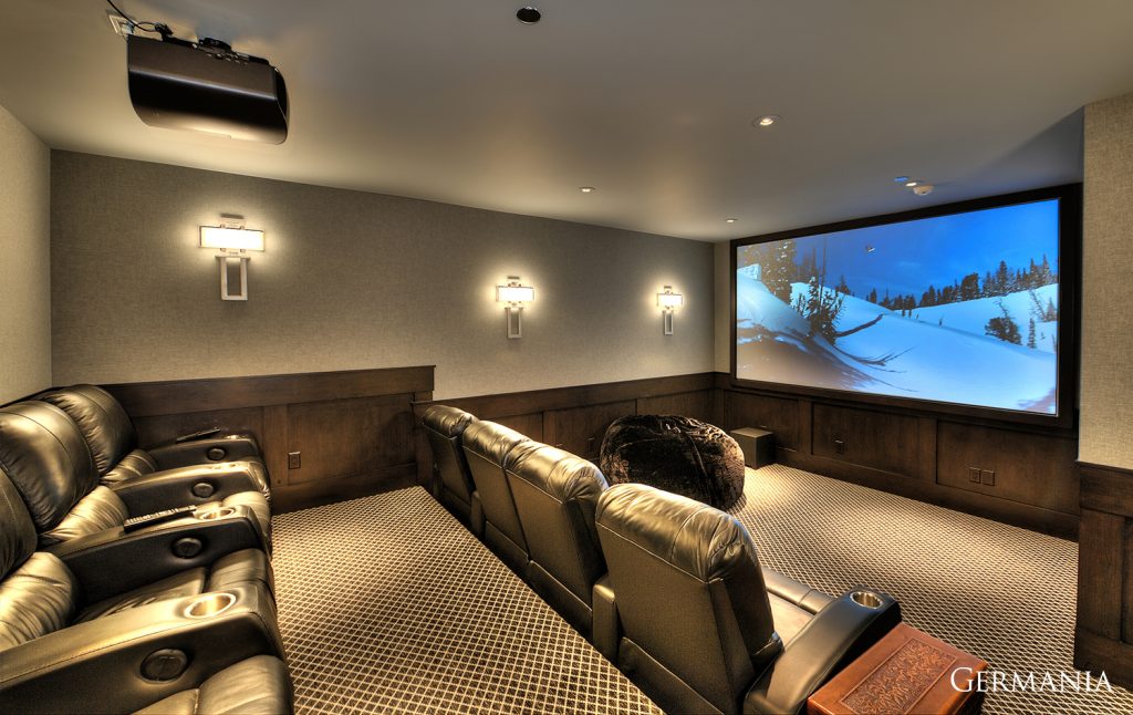 Germania Construction are the custom home builder professionals in Park City and surrounding regions. Featured here is a theater room with wainscotting and custom sconces to fit.