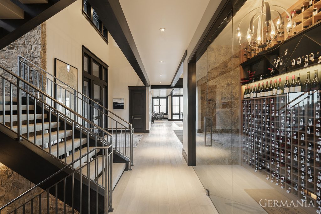 Your vacation home wine room can be one of the most memorable elements of your luxury home. This one features a massive glass door and a beautiful light fixture to give your wine the perfect home.