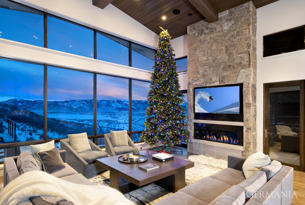 A beautiful living room decorated for the holidays with floor to ceiling windows overlooking the valley