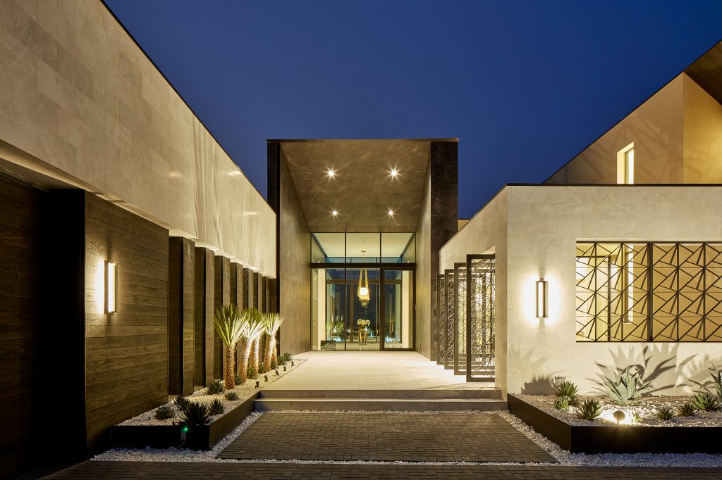 Palms, lights, and pavers turn this front entrance into a welcoming sight.