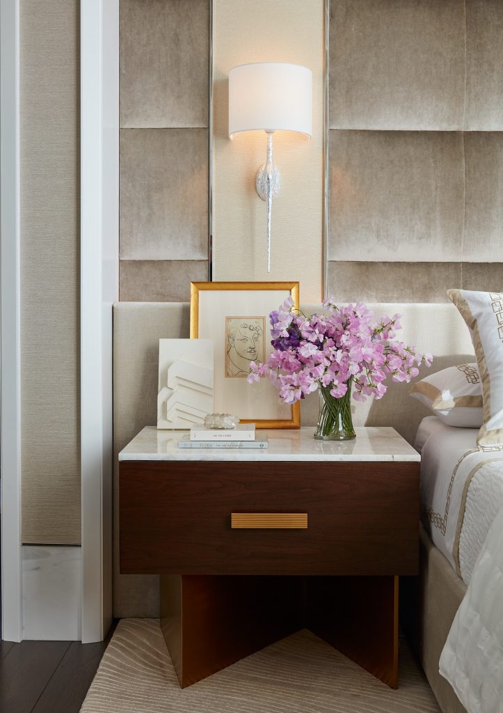 A simple wall mounted light illuminates the bedside area of this master bedroom.