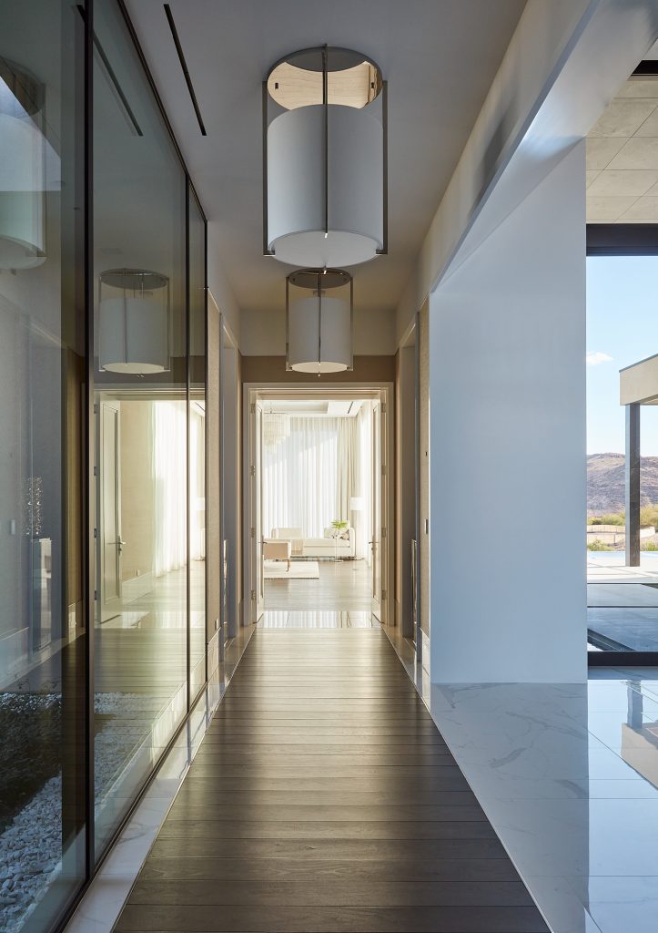 Floor to ceiling windows line this modern hallway.