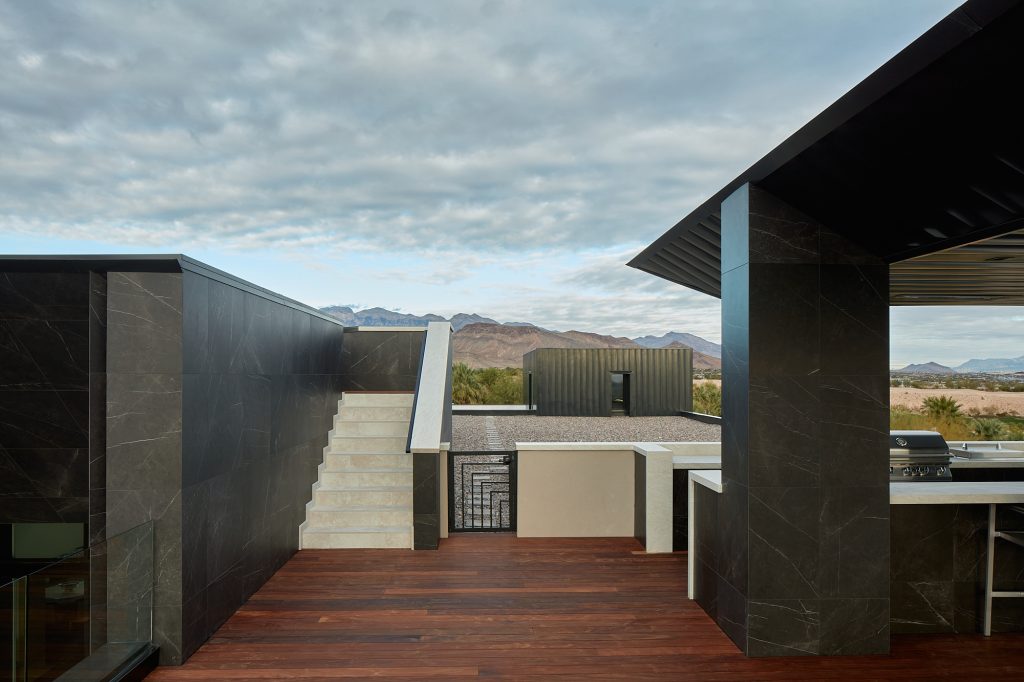 Take a peek at the edge of this outdoor kitchen grill and entrance to the pool.