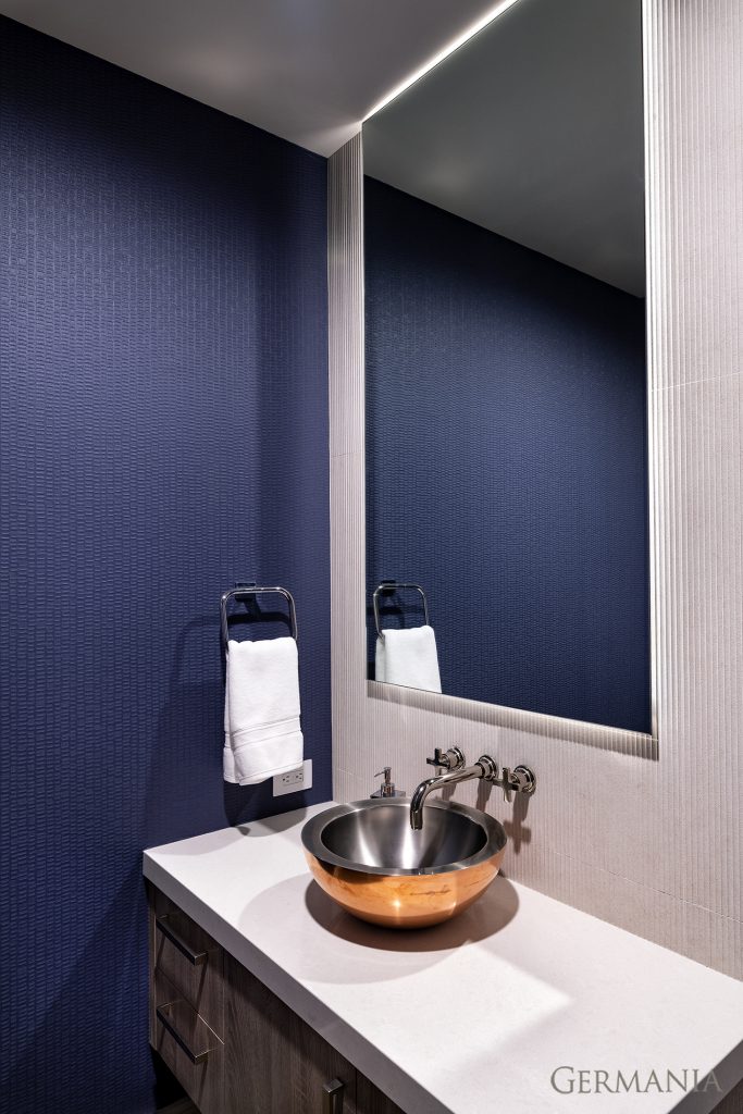 Beautiful textured wallpaper and a unique basin sink give this bathroom a luxurious feel.
