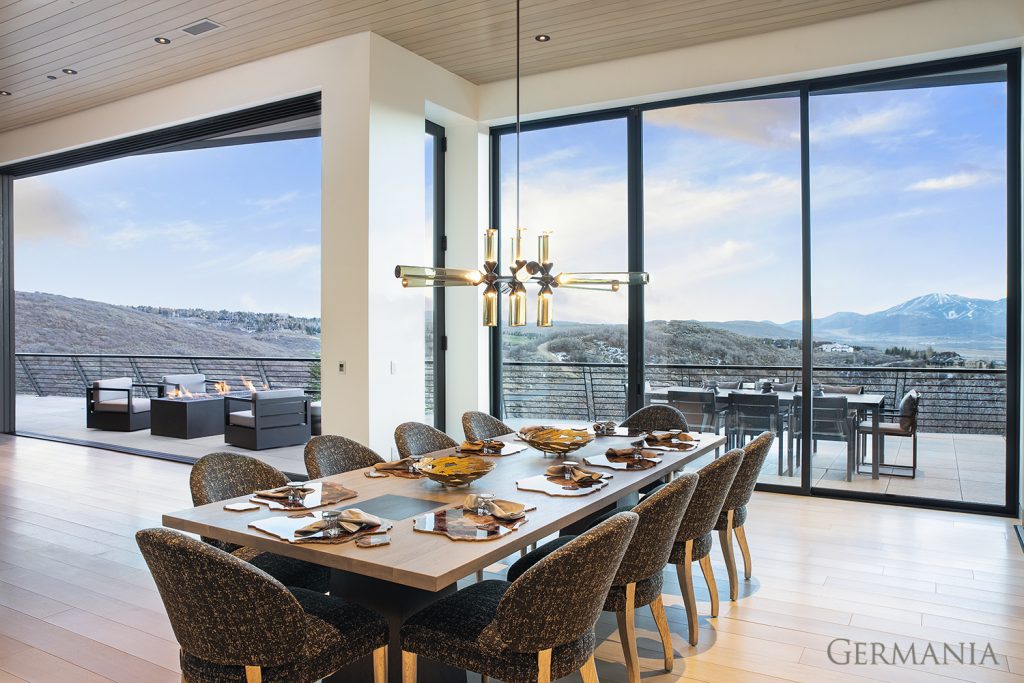 Beautiful, luxury, custom-built dining room with massive windows and beautiful mountain views.