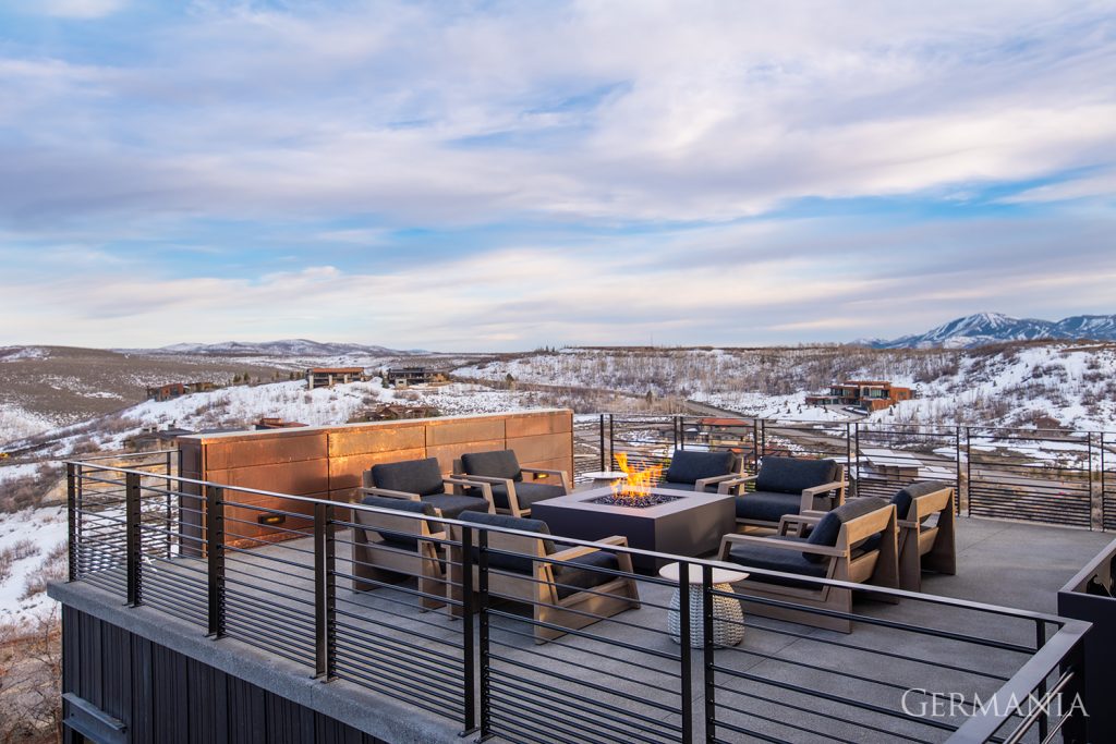 Luxury, custom-built rooftop deck in Park City, UT, with a fireplace and high-end seating.