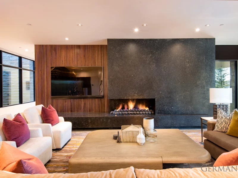 High-end, custom-built, luxury living room in Park City, UT with a large, built-in fireplace.