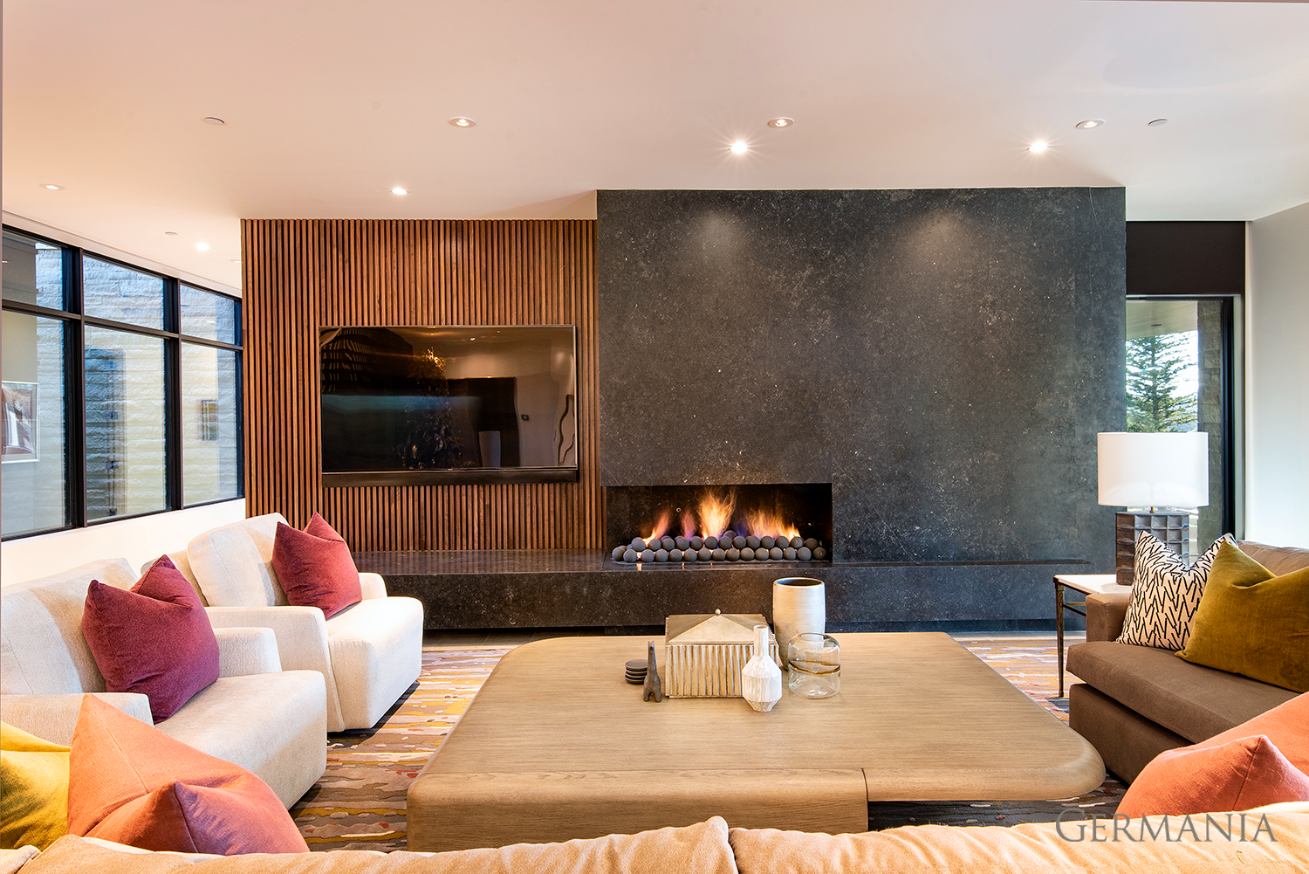 High-end, custom-built, luxury living room in Park City, UT with a large, built-in fireplace.